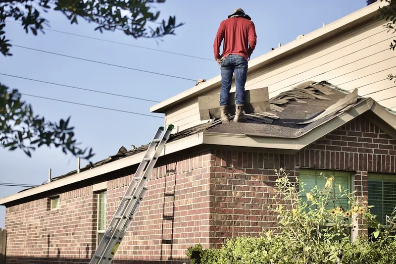 Professional roofer working on a residential roof in Sweetser